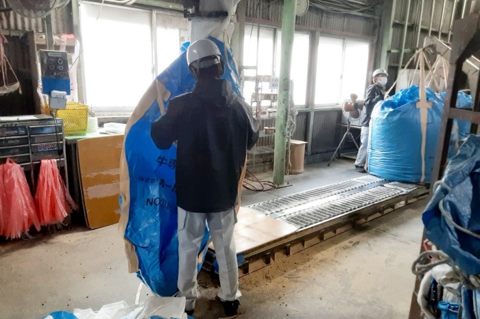 飼料を入れる袋を機械にセッティングし袋詰めします